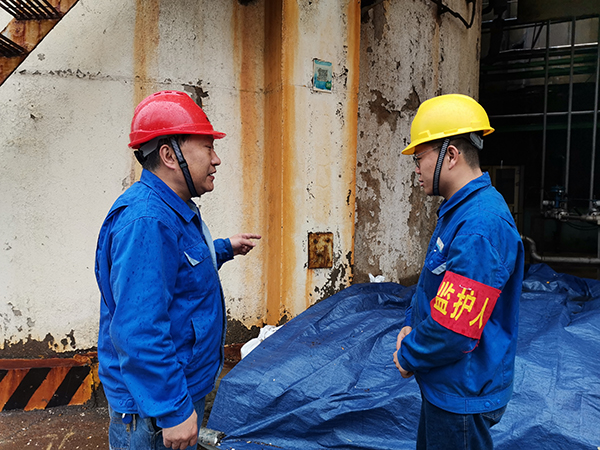 3月31日上午，在一期鍋爐舊脫硫塔底部清理現(xiàn)場，安全員焦路秦對監(jiān)護(hù)人岳維哲的提問。.jpg