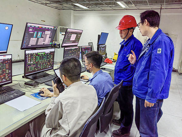 5月13日，動(dòng)力車間三期鍋爐控制室，DCS改造工藝、儀表、電氣等部門聯(lián)合調(diào)試，車間主任姜軍虎與技術(shù)員畢加佳查看調(diào)試過(guò)程.jpg