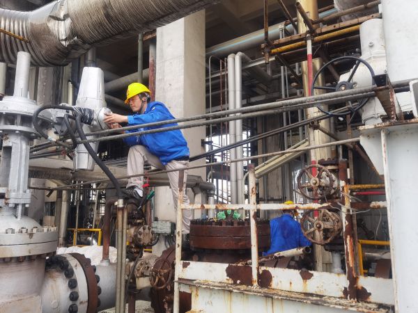 氣化爐上，柳曦、徐騰飛冒雨調(diào)試氣化爐電動(dòng)閥.jpg